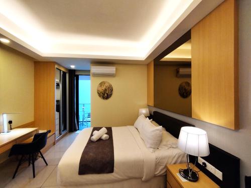 a bedroom with a large bed with a desk and a desk at TopGenting BambooColdSuite4Pax @GrdIonDelmn in Genting Highlands