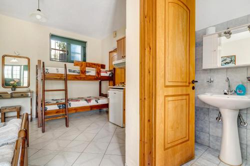 un bagno con lavandino e una camera con letti a castello di Daratos studio 5 a Cefalonia
