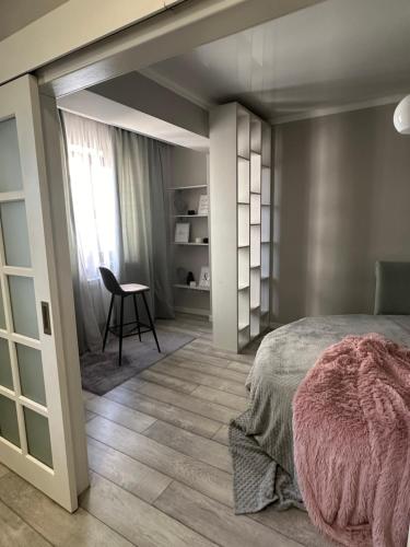 - une chambre avec un lit, une table et une chaise dans l'établissement Latifa Residence, à Almaty