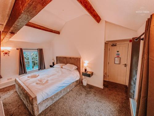 Bamber Bridge的住宿－Ye Olde Original Withy Trees，一间卧室设有一张大床和一个窗户。