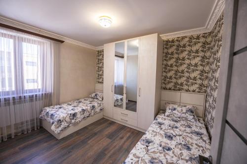a bedroom with two beds and a mirror at Apartment in Ejmiactin in Vagharshapat