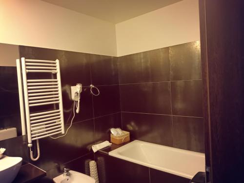 a bathroom with a bath tub and a sink at Rezidencija Grįžulo ratai in Sasnava