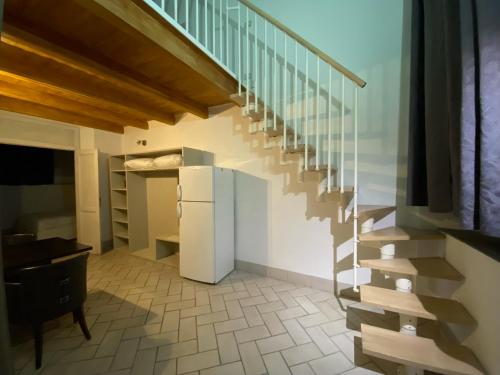 eine Treppe in einem Zimmer mit Kühlschrank in der Unterkunft Borghese Palace Art Hotel in Florenz