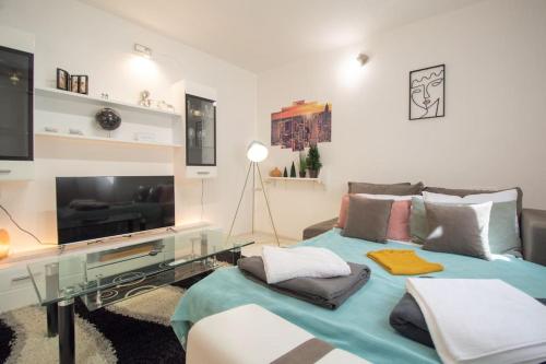 a living room with a couch and a flat screen tv at Central duplex apartment in Novi Sad