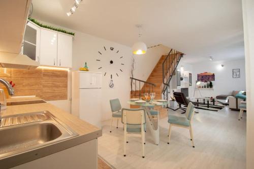 cocina y sala de estar con reloj en la pared en Central duplex apartment+parking en Novi Sad