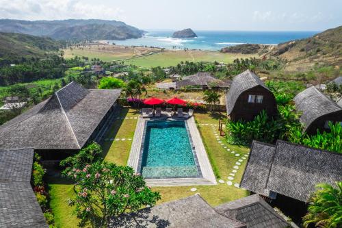 een luchtfoto van een resort met een zwembad en de oceaan bij Villa Ellya Areguling, for 8-10 Pax in Kuta Lombok