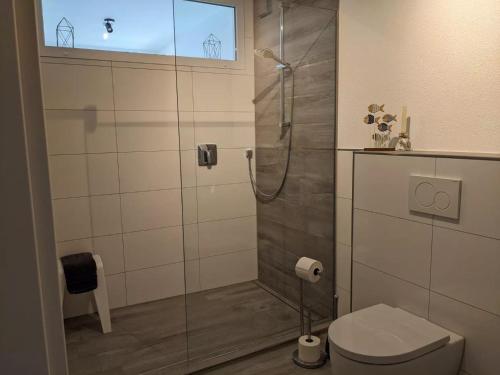 Un baño con ducha de cristal con inodoro. en Fewo New Oberdorf, en Fautenbach