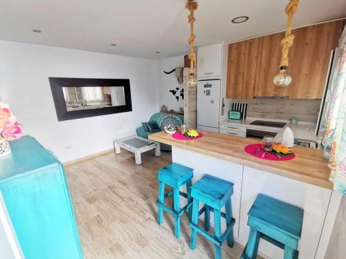 eine Küche mit blauen Hockern und einer Arbeitsplatte in der Unterkunft Apartamento Agua marina con terraza in Chiclana de la Frontera