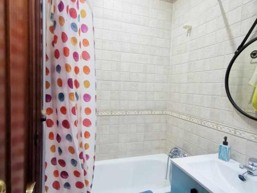 y baño con bañera, lavamanos y cortina de ducha. en Apartamento Agua marina con terraza en Chiclana de la Frontera