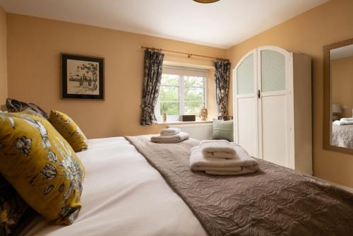 een slaapkamer met een groot bed en handdoeken bij Cossington Park Cottage in Cossington