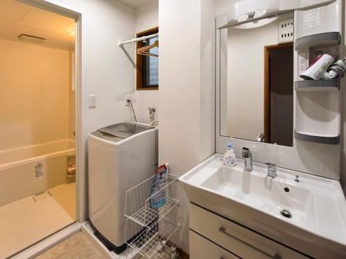 a bathroom with a sink and a washing machine at Ostay Numabukuro Hotel Apartment in Tokyo