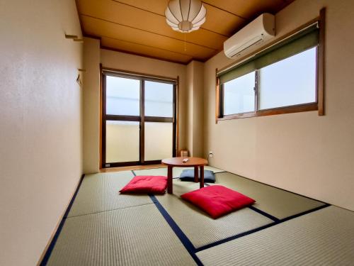 Zimmer mit einem Tisch und zwei roten Matten in der Unterkunft Ostay Numabukuro Hotel Apartment in Tokio