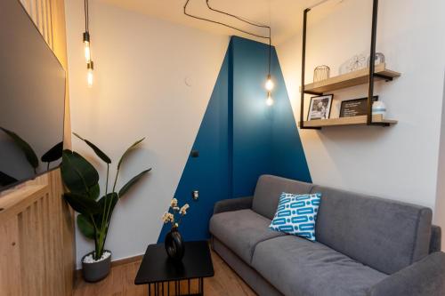 a living room with a couch and a blue accent wall at Valaoritou 3 Luxury Rooms in Thessaloniki