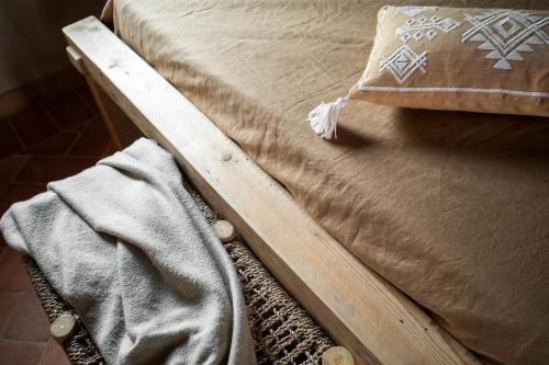 a bed with a wooden frame with a pillow on it at Agriturismo Borgo Malva' in San Venanzo