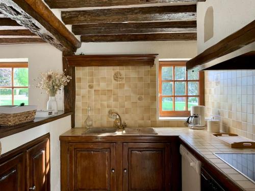 a kitchen with wooden cabinets and a sink at La Cidrerie du Haras in Léaupartie