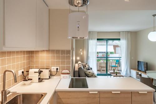 a kitchen with a sink and a living room at Port Cambrils in Cambrils