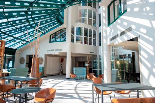 a lobby with tables and chairs and a building at Hotel Amadeus Frankfurt in Frankfurt/Main