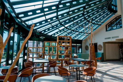 a room with tables and chairs and a glass ceiling at Hotel Amadeus Frankfurt in Frankfurt/Main