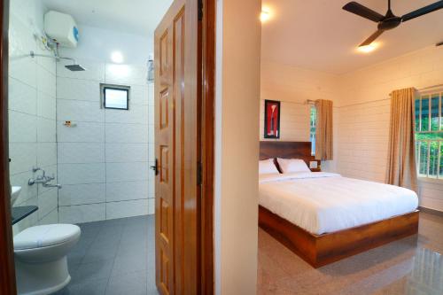 a bedroom with a bed and a shower and a toilet at 10 Degrees North By Avni Holidays in Idukki