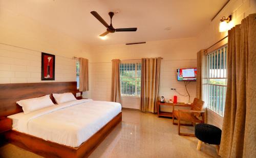 a bedroom with a bed and a desk and a television at 10 Degrees North By Avni Holidays in Idukki