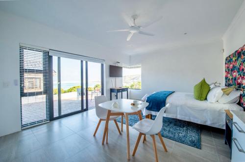 a bedroom with a bed and a table and chairs at Struisbaai Apartments in Struisbaai