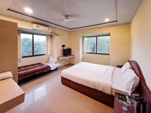 a hotel room with two beds and two windows at Hotel Blue Valley in Mount Ābu