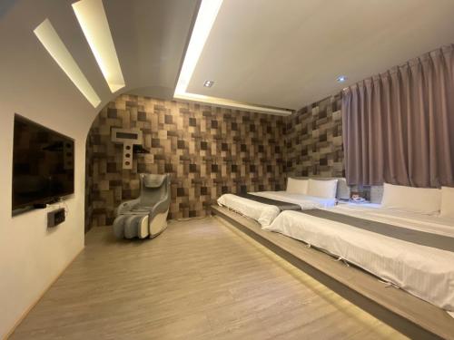 a bedroom with two beds and a flat screen tv at Yuan Chyau Motel in Taichung