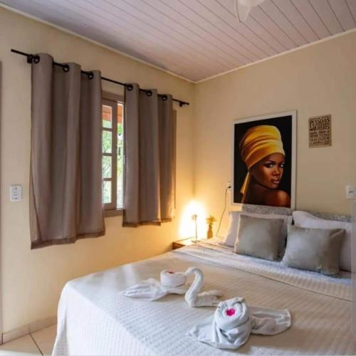 ein Schlafzimmer mit einem Bett mit einem Bild einer Frau in der Unterkunft Suíte alvenaria casal. in Guabiruba