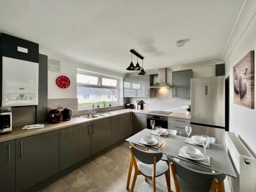 a kitchen with a table and chairs and a refrigerator at Havenwood House - Great for Contractors or Family Holidays in Nottingham