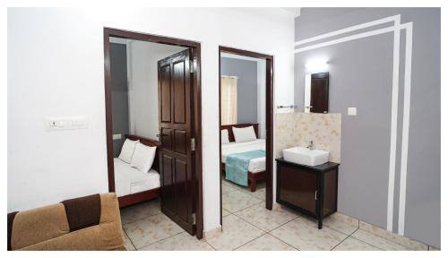 - une chambre avec un lit et un miroir dans l'établissement Noel Apartments, à Cochin