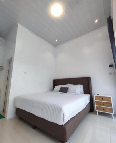 ein Schlafzimmer mit einem großen Bett und einem Nachttisch in der Unterkunft Kinkeo Borobudur in Magelang
