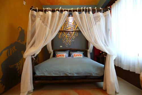 a bedroom with a canopy bed with white curtains at Sweet Heart B&B in Jian
