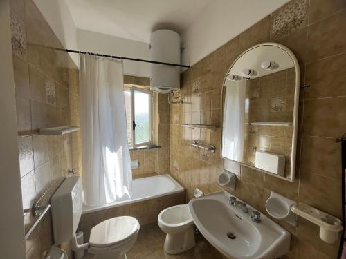 uma casa de banho com um lavatório, um WC e uma banheira em Luminoso appartamento con ampia terrazza em San Bartolomeo al Mare