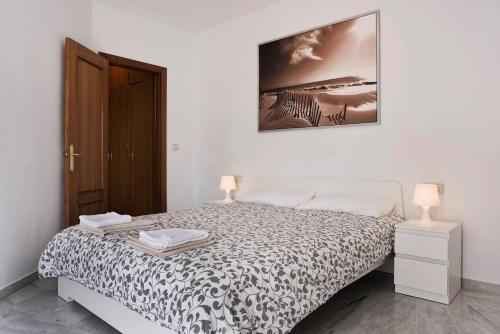 een slaapkamer met een bed en een foto aan de muur bij Exclusive Malaga Apartments with Cathedral Views and Auto Check-in in Málaga