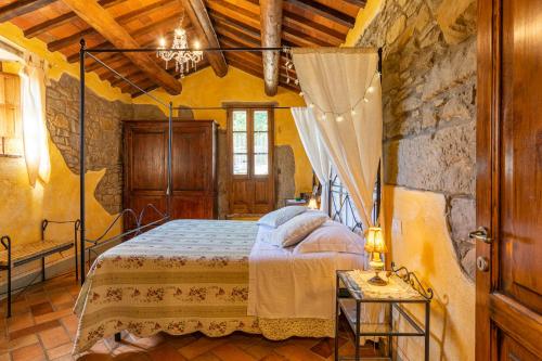 1 dormitorio con 1 cama en un edificio de piedra en Borgo Dolci Colline Resort Querce, en Castiglion Fiorentino