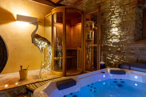 El baño incluye una bañera con una estatua de un pájaro. en Borgo Dolci Colline Resort Querce, en Castiglion Fiorentino