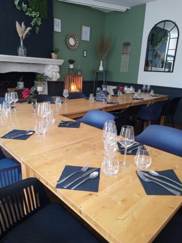 een grote houten tafel met glazen en servetten erop bij ARÔMA - anciennement l'Instant B in Blain