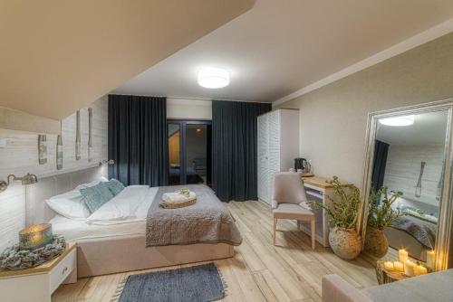 a bedroom with a bed and a chair in a room at Natura Mierzei 30 - pokoje przy plaży in Krynica Morska
