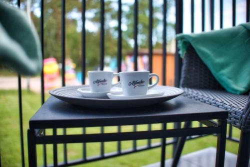 two cups of coffee sitting on a table at Natura Mierzei 30 - pokoje przy plaży in Krynica Morska