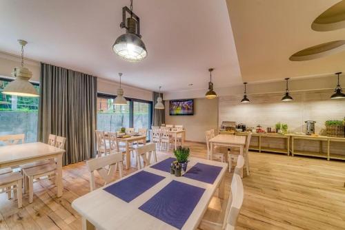 a dining room with a table and chairs and a kitchen at Natura Mierzei 30 - pokoje przy plaży in Krynica Morska