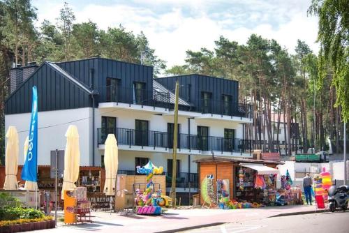 a building with umbrellas and a market in front of it at Natura Mierzei 30 - pokoje przy plaży in Krynica Morska