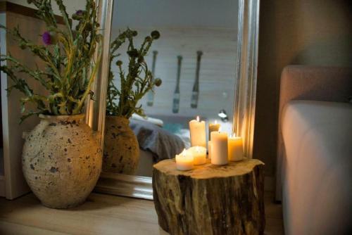 a room with a mirror and candles on a table at Natura Mierzei 30 - pokoje przy plaży in Krynica Morska