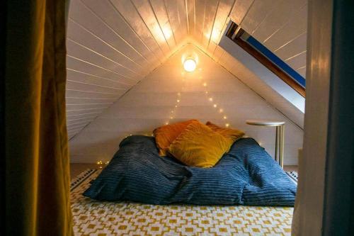 a bed in a attic with a light on it at Quirky 2-bed flat w/ parking central Kingsbridge in Kingsbridge