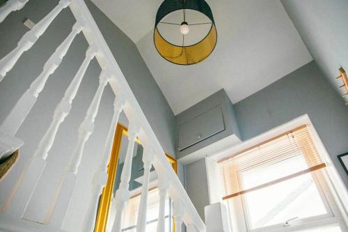 a white staircase with a window and a clock on the ceiling at Quirky 2-bed flat w/ parking central Kingsbridge in Kingsbridge
