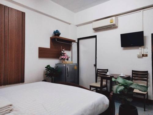 1 dormitorio con 1 cama, mesa y sillas en Baan Rao Boutique Residence, en Chiang Mai