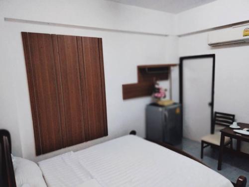 1 dormitorio con 1 cama y puerta de madera en Baan Rao Boutique Residence, en Chiang Mai