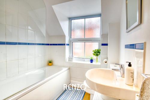 a white bathroom with a tub and a sink at Homely and Cosy 3-bed Home in Lincoln by Renzo, Amazing Location, Close to Cathedral and Castle! in Lincolnshire