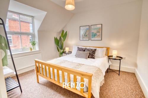 1 dormitorio con cama de madera y ventana en Sentimental and Homely 3-bed Home in Lincoln by Renzo, Amazing Location, Close to Cathedral and Castle!, en Lincoln