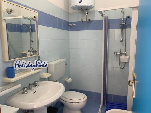 baño azul y blanco con aseo y lavamanos en Villetta Leucasia by Holiday World, en Leuca