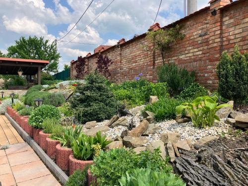 a garden with rocks and plants next to a brick wall at Penzion U Kostela in Kuželov
